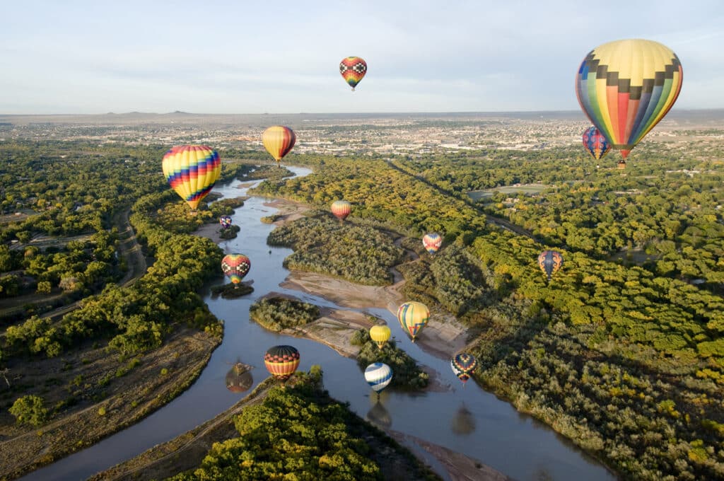 hot air balloons over a river in Albuquerque, NM