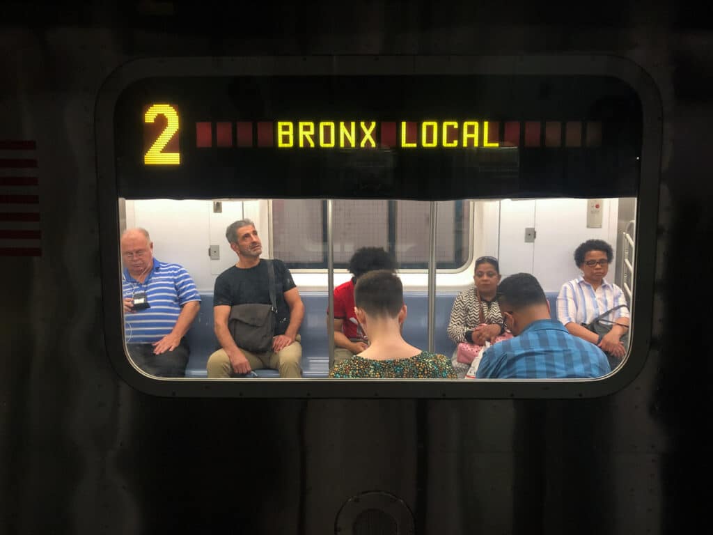 People on the number 2 bronx local subway late in the day.