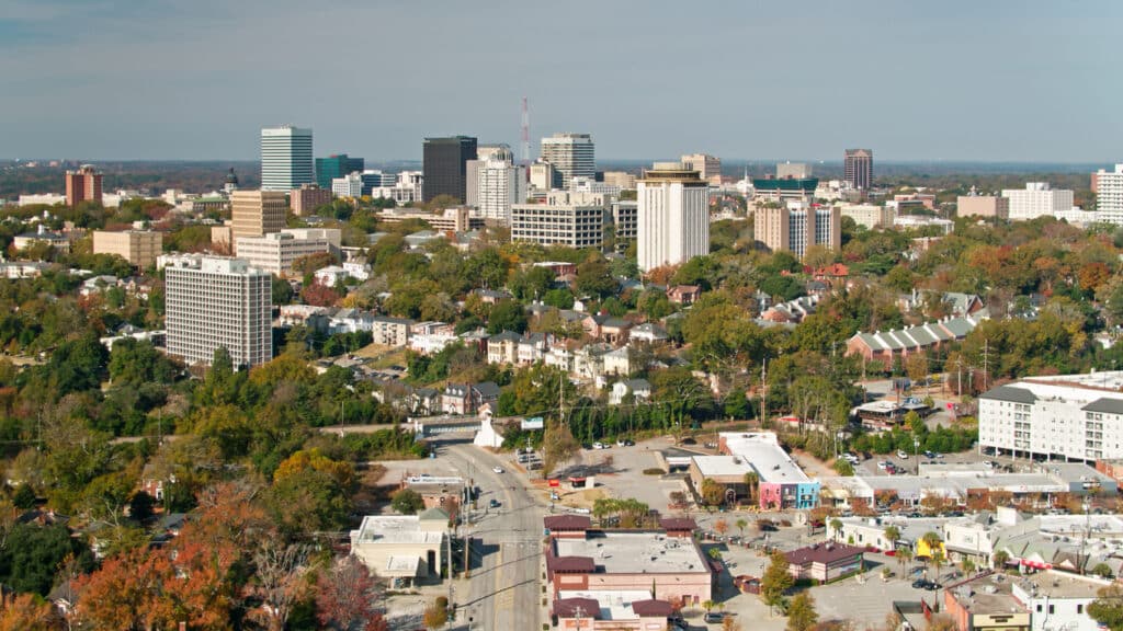 Aerial Shot of Columbia, SC, looking across the rooftops and the University of South Carolina campus towards downtown office towers and the state house.