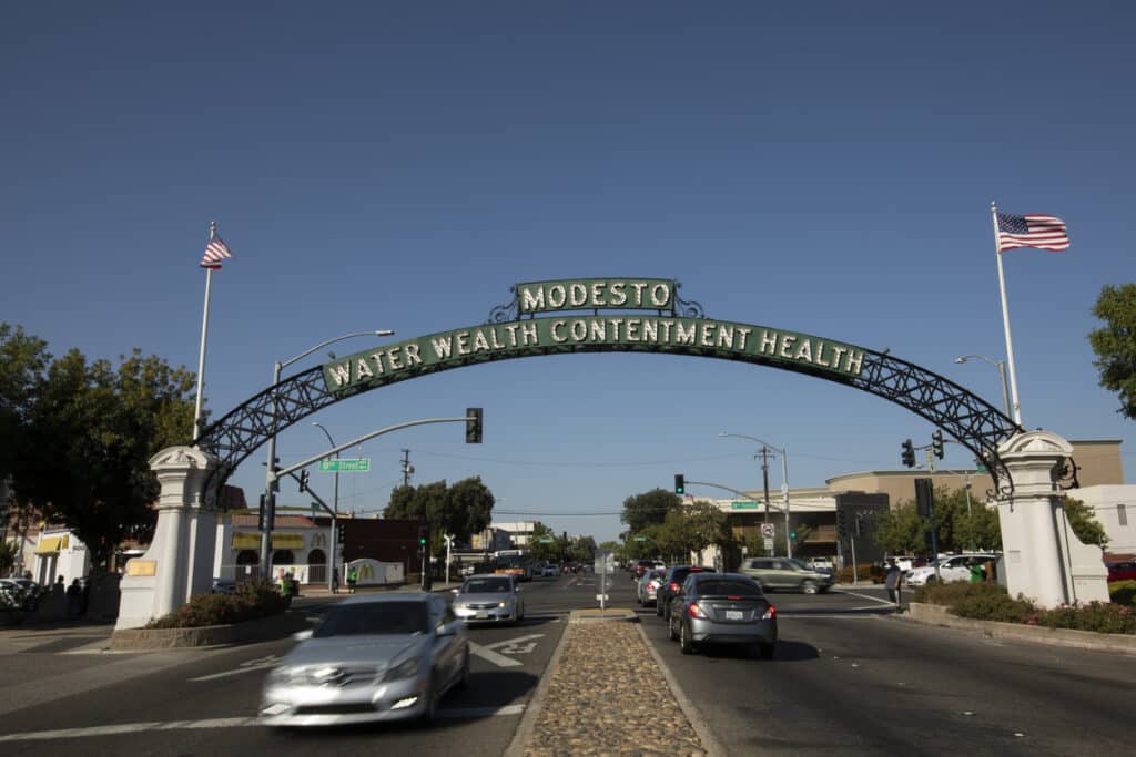 Daytime view of the historic 1912 Modesto Arch as it spans over I Street through downtown Modesto.