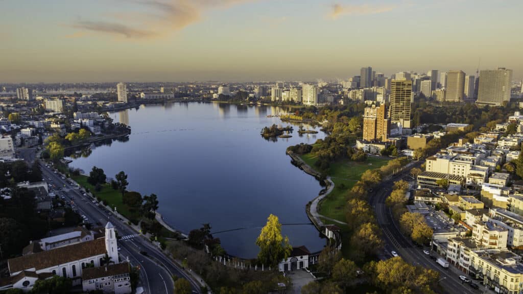 Aerial stock photo of downtown Oakland California and Lake Merritt early in the morning at sunrise.