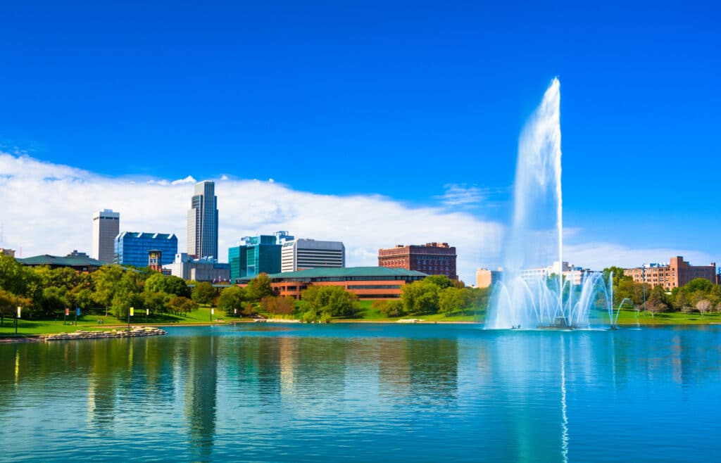 Downtown Omaha skyline with a Lake and a large ornate fountain in the Heartland of America Park.
