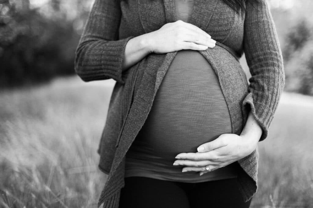 A pregnant women putting her hands on her baby bump